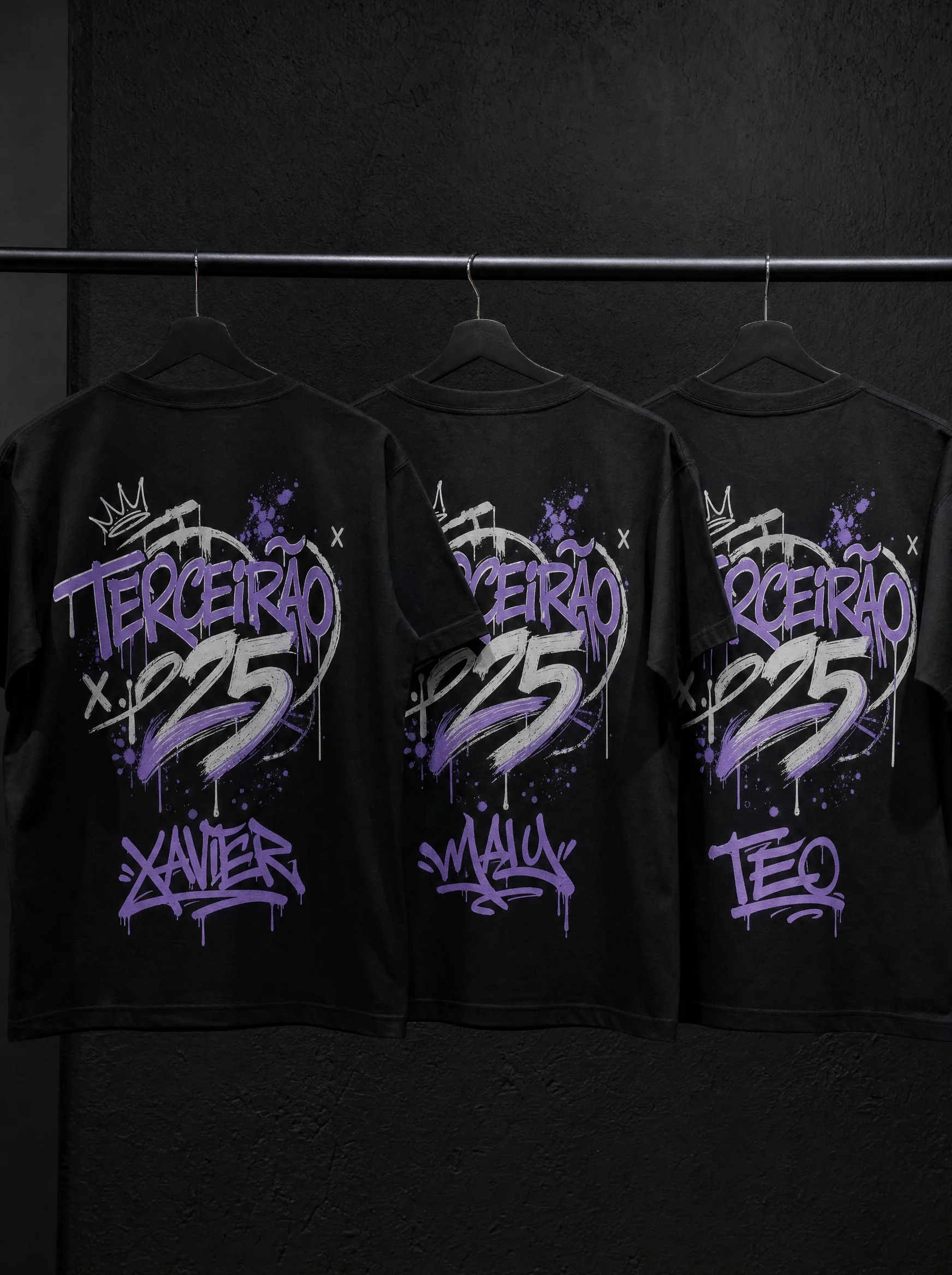 Três camisetas de terceirão penduradas mostrando nomes diferentes de formandos em tag
